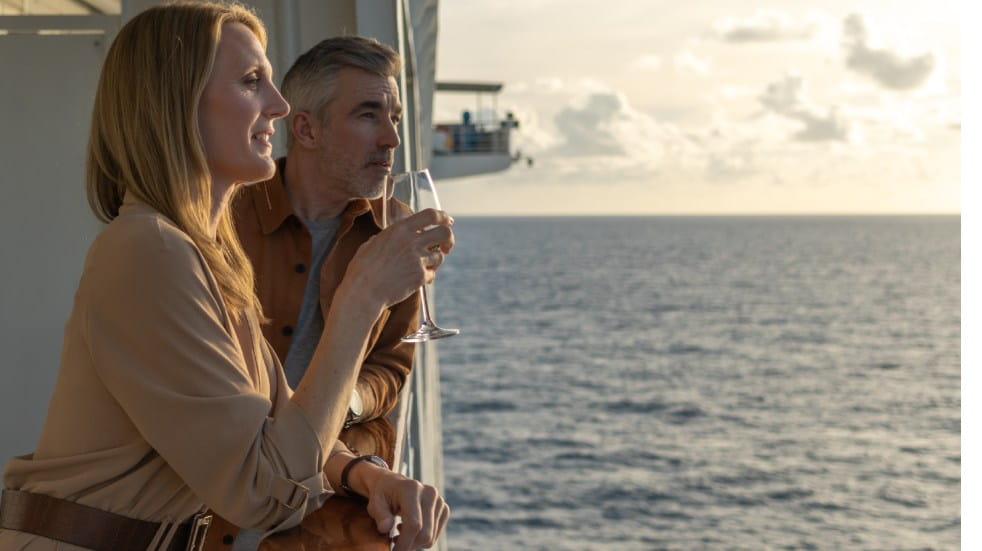 Outside shot of couple on suite balcony onboard an Ambassador cruise